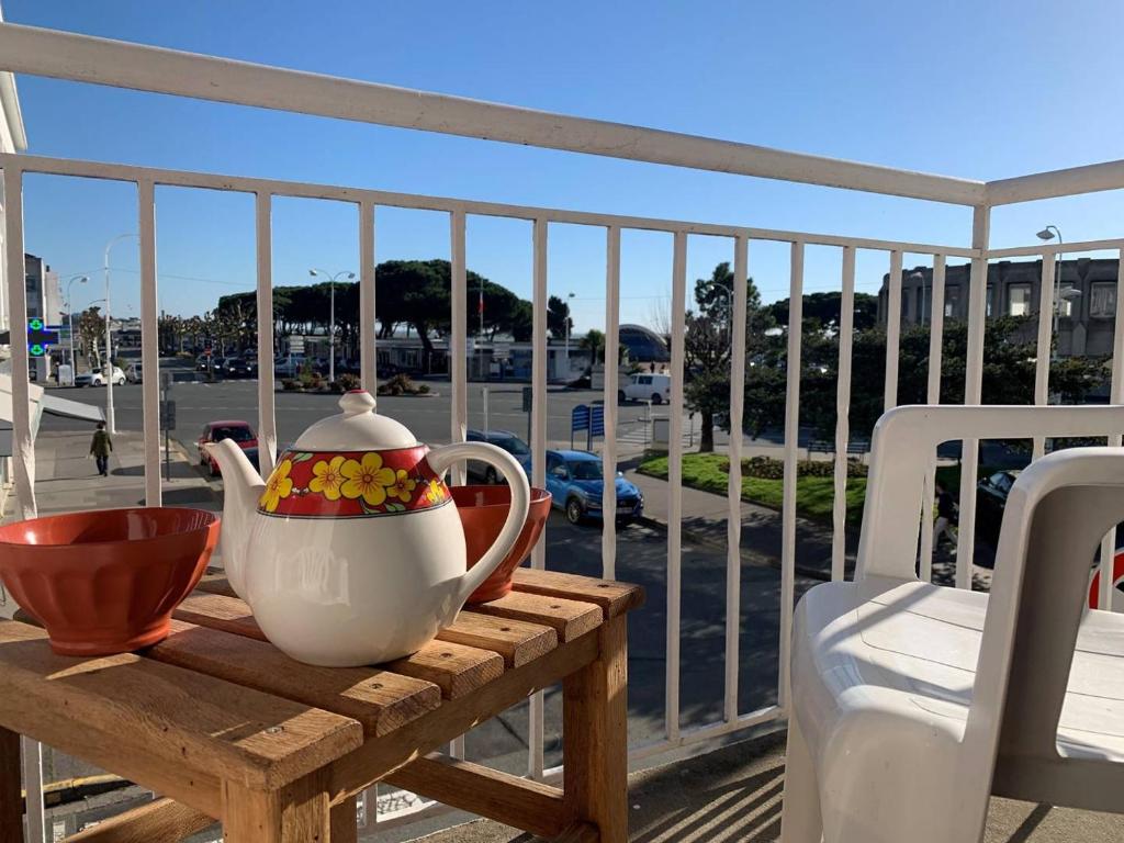 - une table en bois avec une théière et un pichet sur un balcon dans l'établissement Royan - APPARTEMENT au coeur du CENTRE-VILLE - PLAGE à 200m SEULEMENT, à Royan