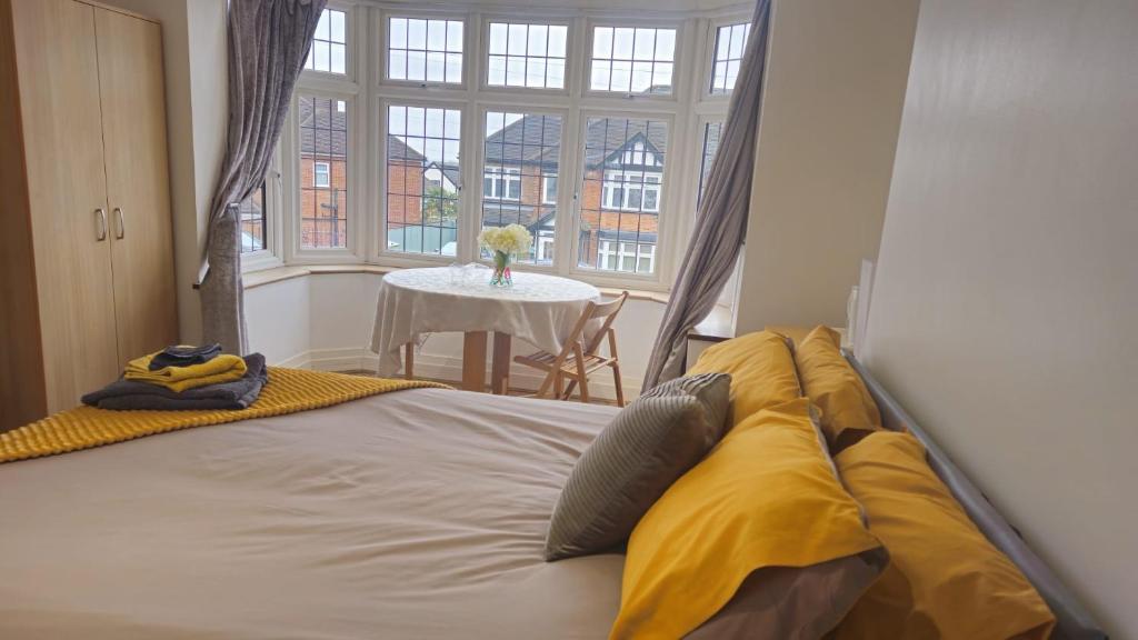 Cama con sábanas amarillas en una habitación con mesa en Cosy Studio Wembley Stadium Gem, en Wembley