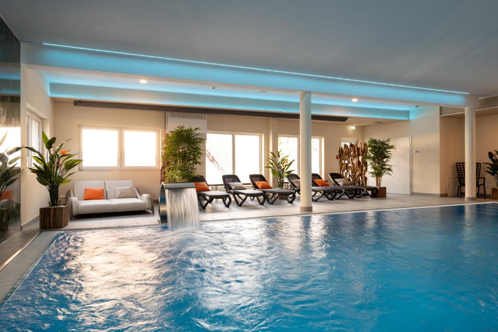 ein großer Pool in einem Gebäude mit Stühlen in der Unterkunft Spreewaldhotel Stephanshof in Lübben