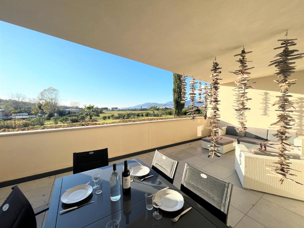 une salle à manger avec deux tables et une grande fenêtre dans l'établissement Appartement Le Frasso PORTICCIO, à Porticcio