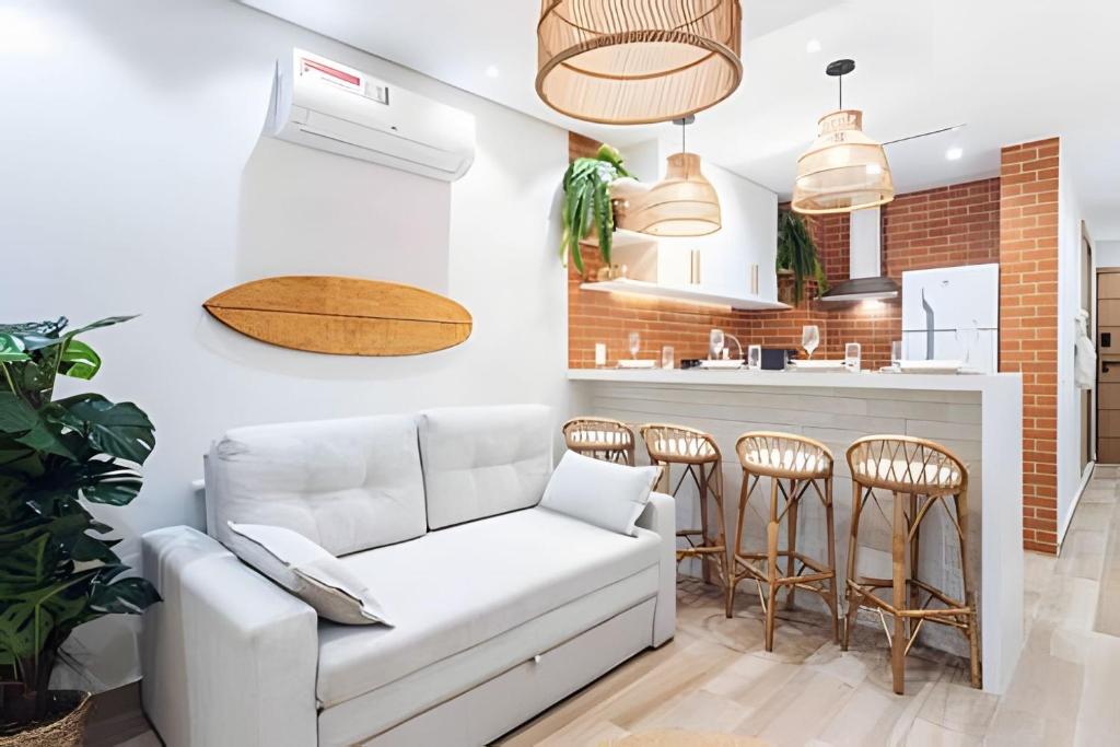 a living room with a white couch and a kitchen at Copa Beach Studios Design in Rio de Janeiro