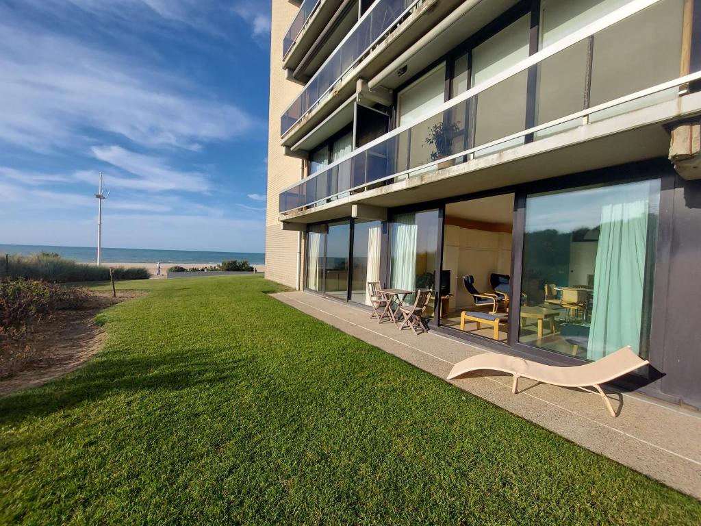 a building with a yard with a view of the ocean at Studio Zeedijk Koksijde in Koksijde
