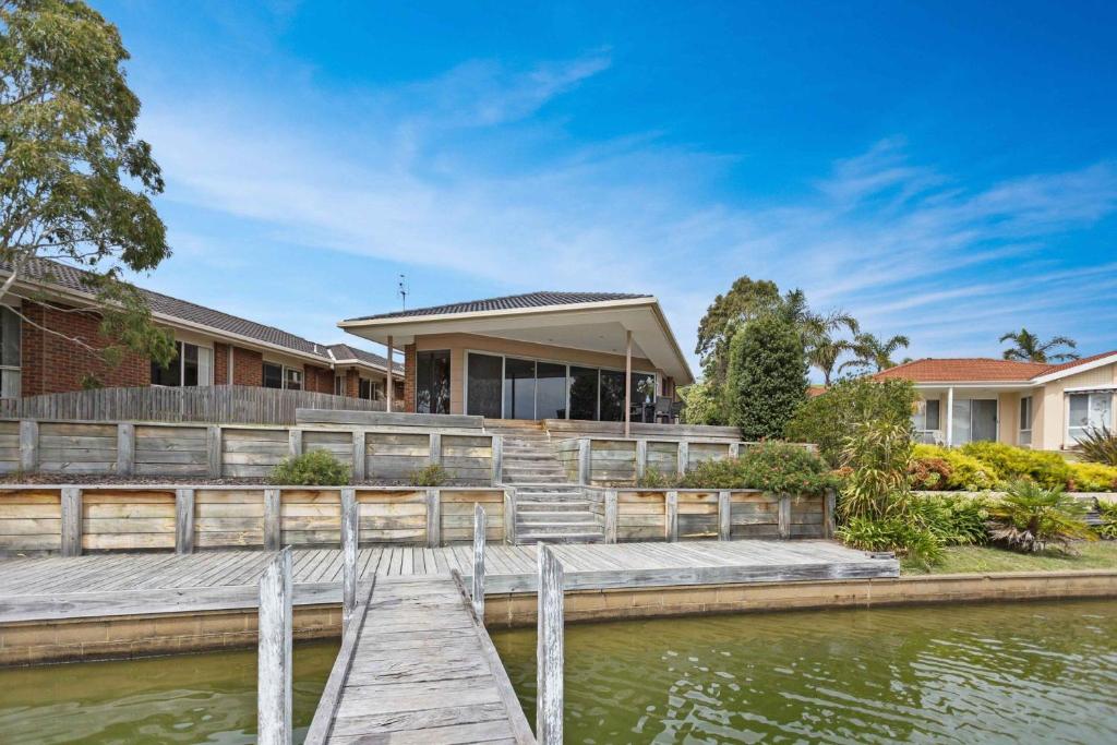 a house with a dock next to a body of water at Pelican Brief in Paynesville