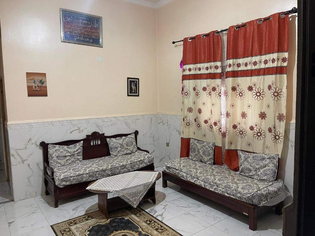 ein Wohnzimmer mit 2 Stühlen und einem Vorhang in der Unterkunft Two bedroom with garden in Constantine