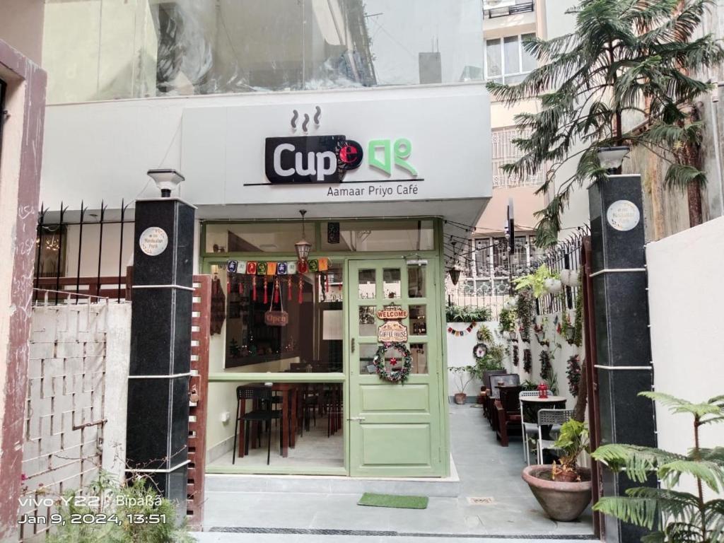 uma loja de copos com uma porta verde em frente em The Broome Kolkata em Calcutá