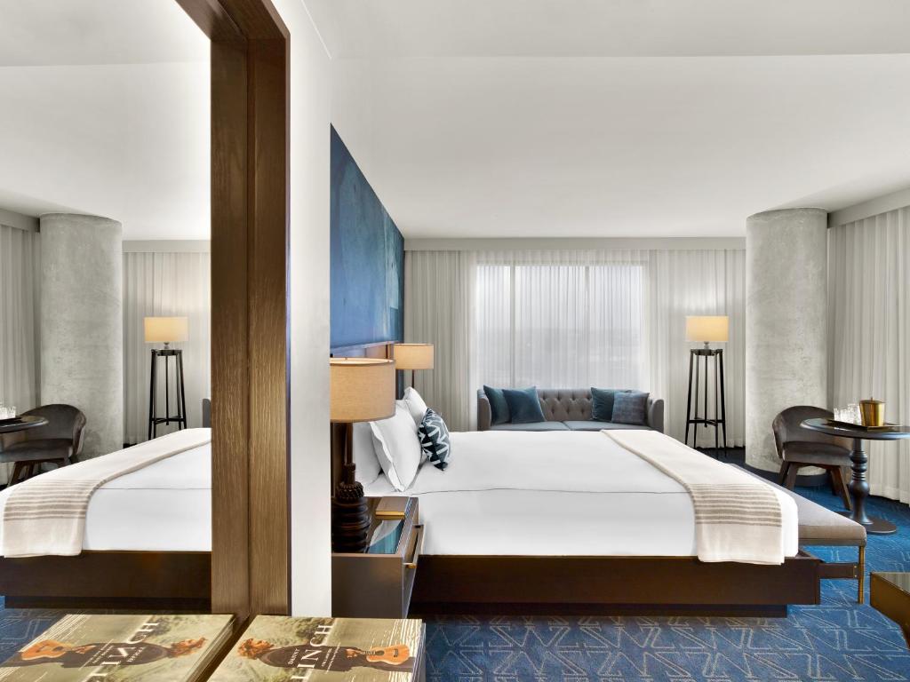 a hotel room with two beds and a couch at Hotel Van Zandt in Austin