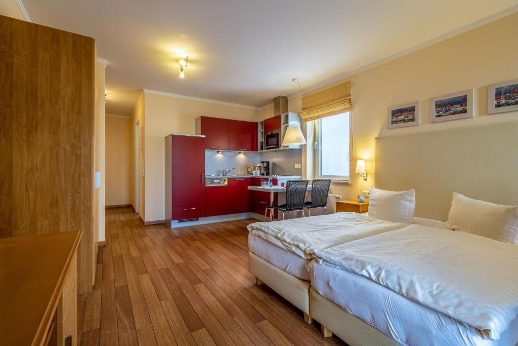 a hotel room with a bed and a kitchen at Hafendomicil Appartement WH11 - Eichhörnchen in Waren