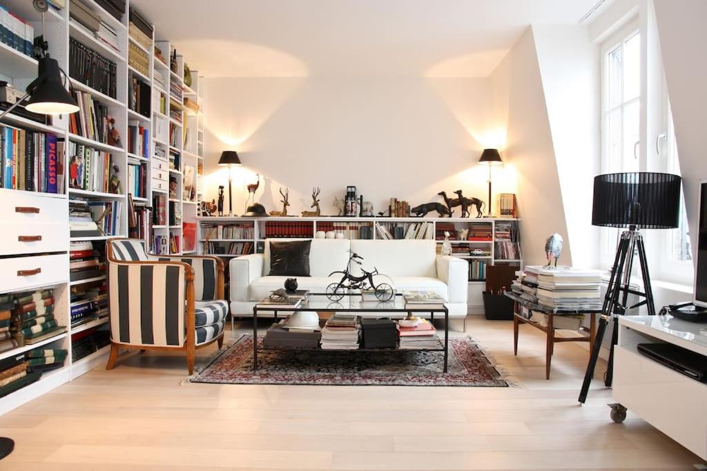 un salon avec un canapé blanc et une table dans l'établissement PARIS SOUS LES TOITS, à Paris