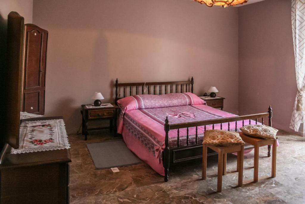 a bedroom with a bed with pink sheets and two tables at Brother's Home in Civitella Casanova
