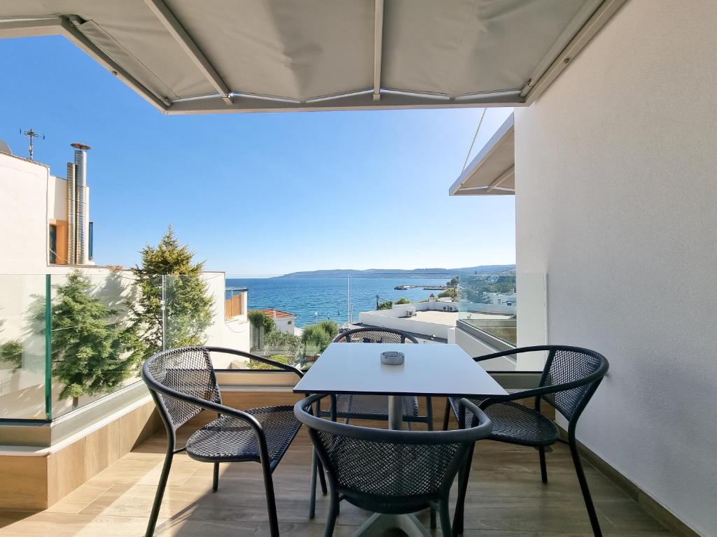 キオスにあるXENIA LUXURY APARTMENTS CHIOSのテーブルと椅子、海の景色を望むバルコニー