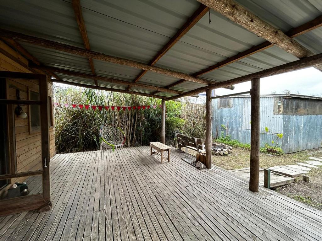 una terraza de madera con 2 bancos y una mesa en Hippie home!, en Maldonado