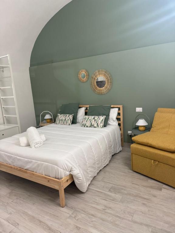 a bedroom with a large bed and a chair at Corte Capuana in Catania