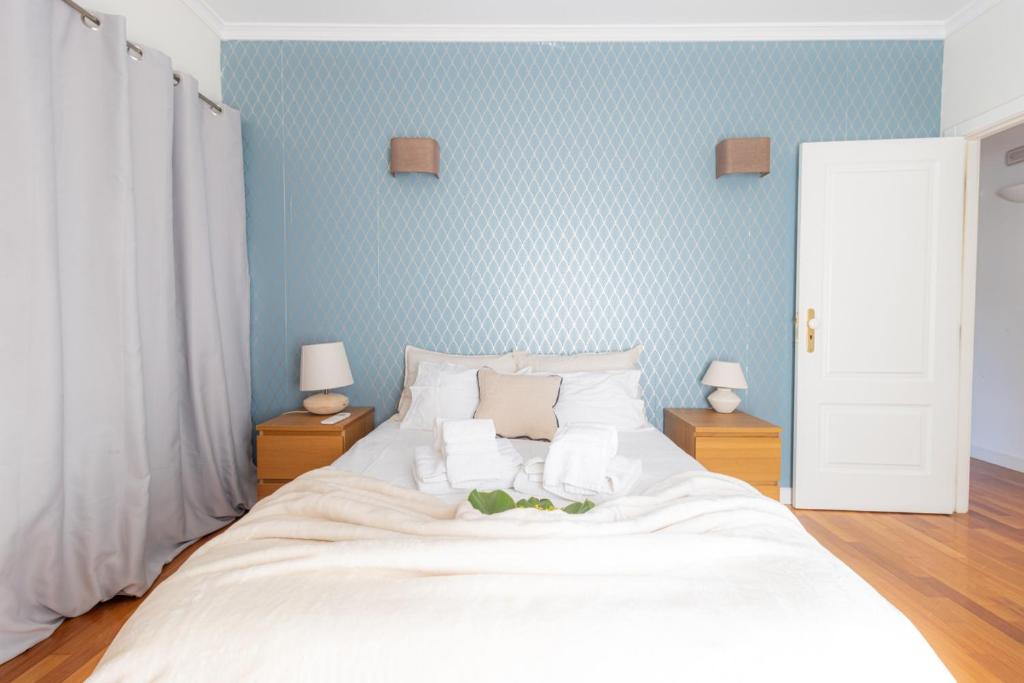 een slaapkamer met een groot wit bed met blauwe muren bij Quinta Moinhos da Tapada in Luso