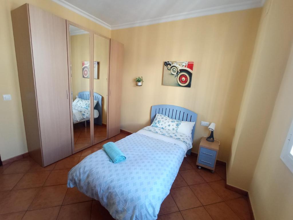 Dormitorio pequeño con cama y espejo en Casa La Romana, en Aracena