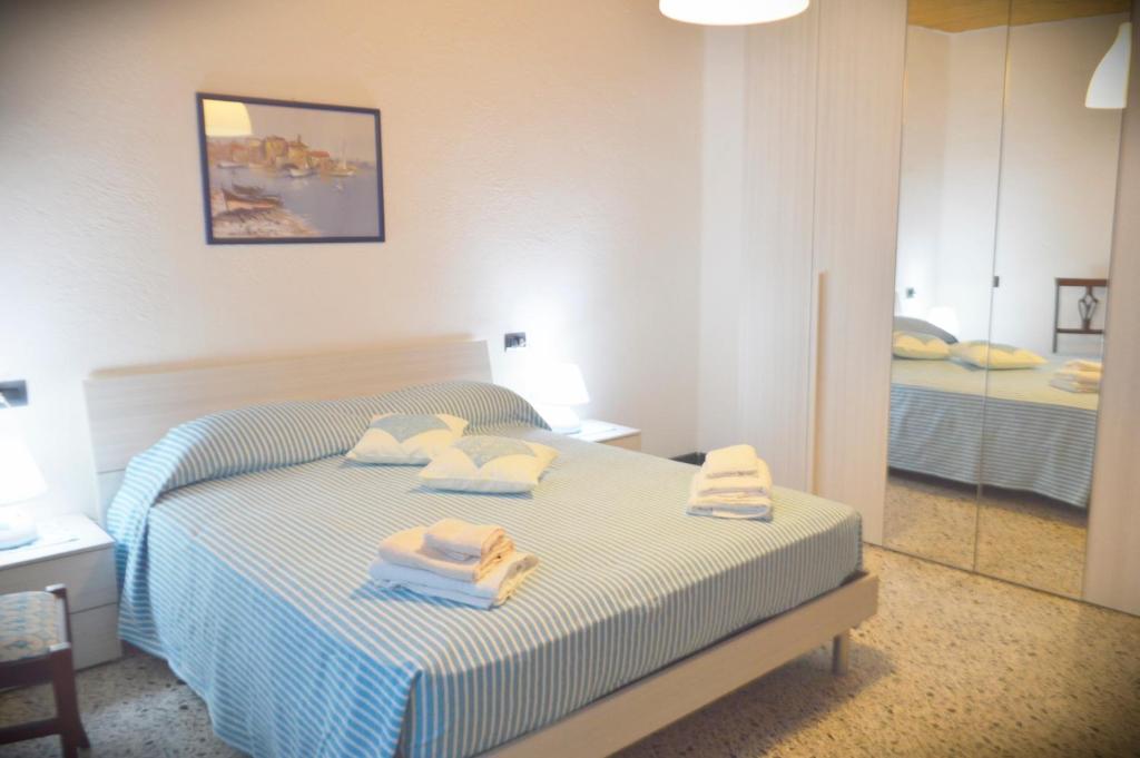 1 dormitorio con 1 cama con toallas en CASA SINGOLA ALLE PORTE DEL SINIS en Baratili San Pietro