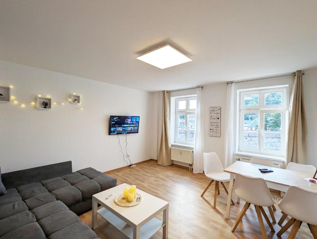 a living room with a couch and a table at Urlaubsmagie - Große Wohnung für bis zu 10 Personen - F4 in Sebnitz