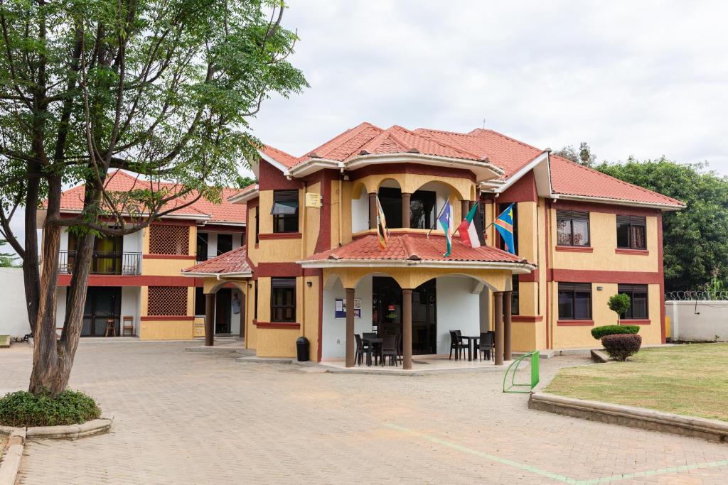um edifício com bandeiras na frente em Missions Cafe Arua - GuestHouse em Arua