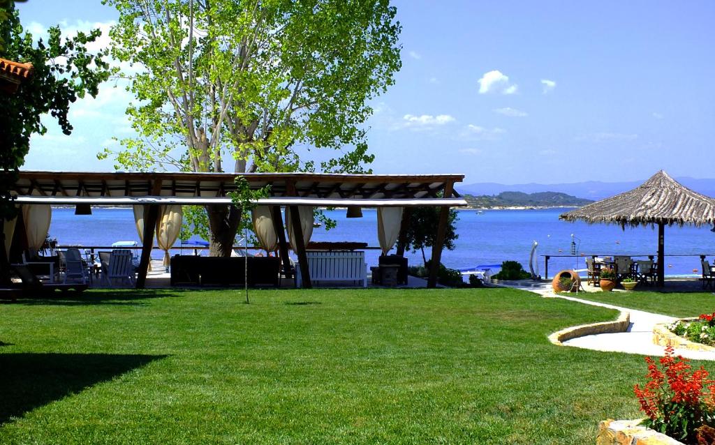 a park with a gazebo next to the water at Christaras Apartments in Vourvourou