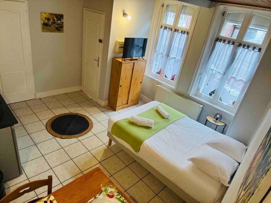 une chambre avec un lit dans une pièce avec des fenêtres dans l'établissement Une pause en baie de Somme, rez de chaussée, Wifi, à Abbeville