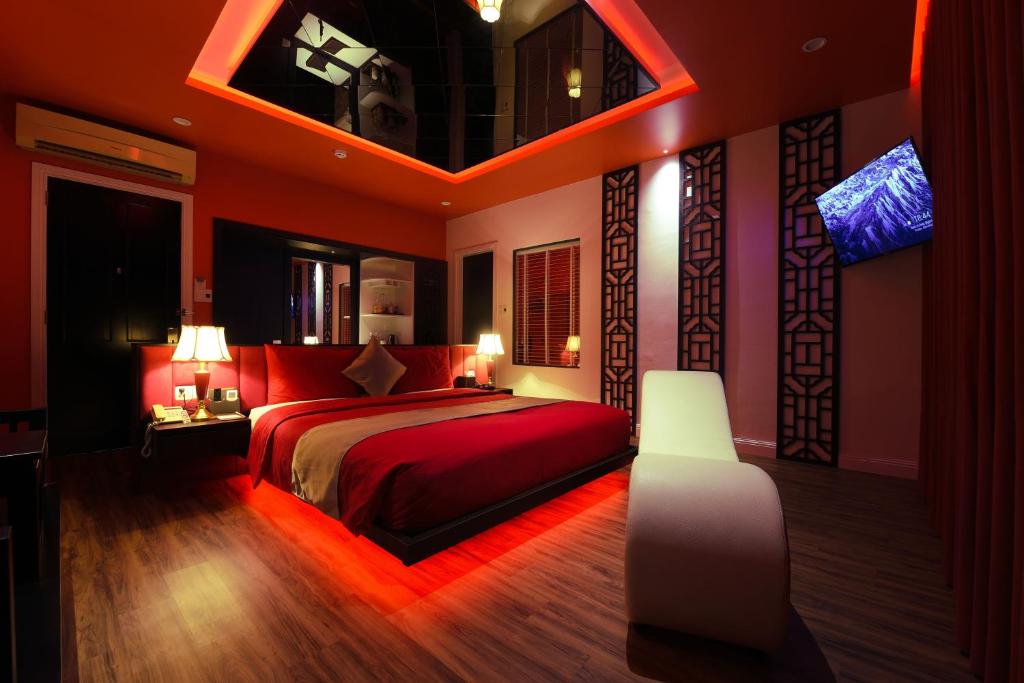 a bedroom with a red bed and a tv in it at Chiic House 3 - Khách sạn tình yêu in Da Nang