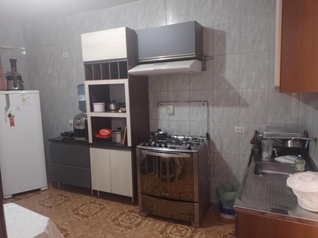 a small kitchen with a stove and a sink at Casa com piscina Temporada Foz do Iguaçu in Foz do Iguaçu