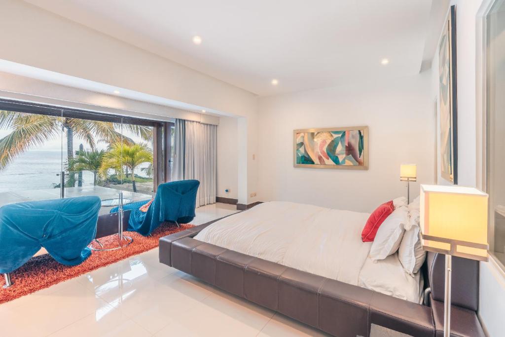 a bedroom with a large bed and a large window at Breakfast Included Marina Town House at Puerto Bahia in Santa Bárbara de Samaná
