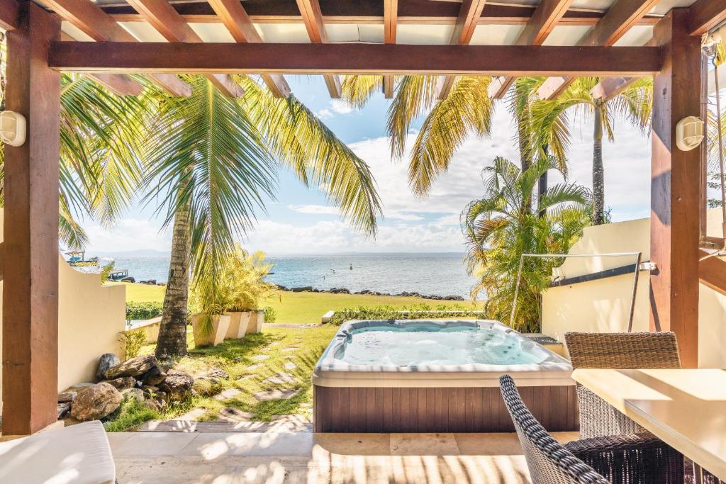 un patio con bañera de hidromasaje y vistas al océano en Breakfast Included Marina Town House at Puerto Bahia, en Santa Bárbara de Samaná