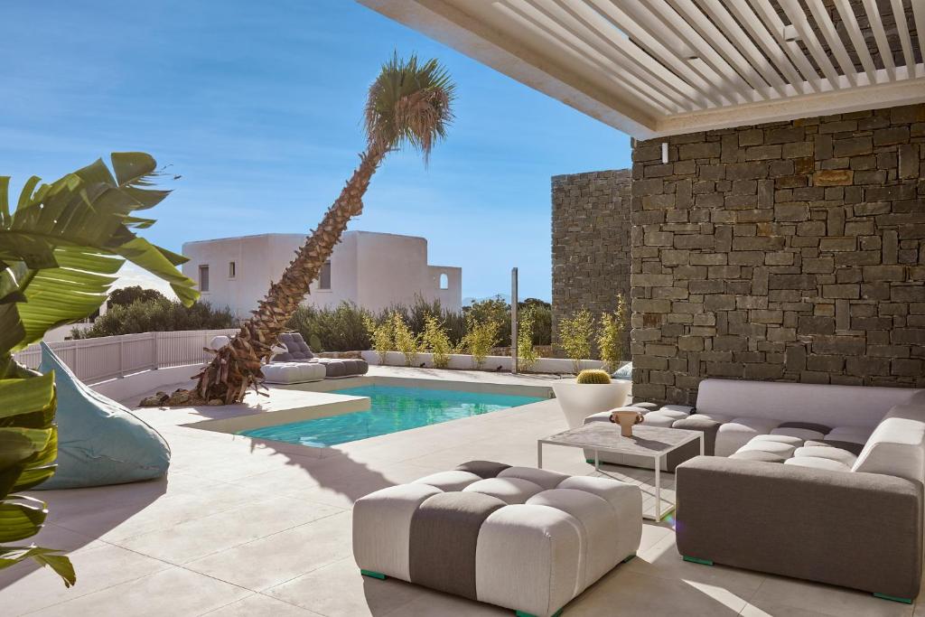 a living room with a palm tree and a pool at Helius Villas in Aliki