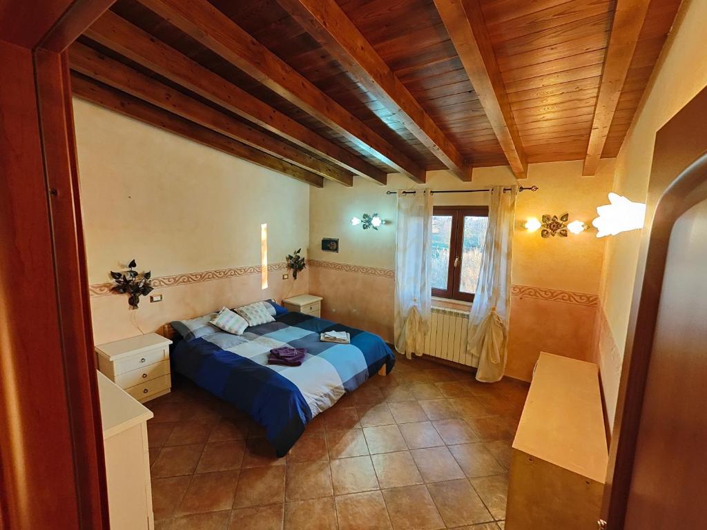 a bedroom with a blue bed and a window at B&B Camera delle Camelie in Palestrina
