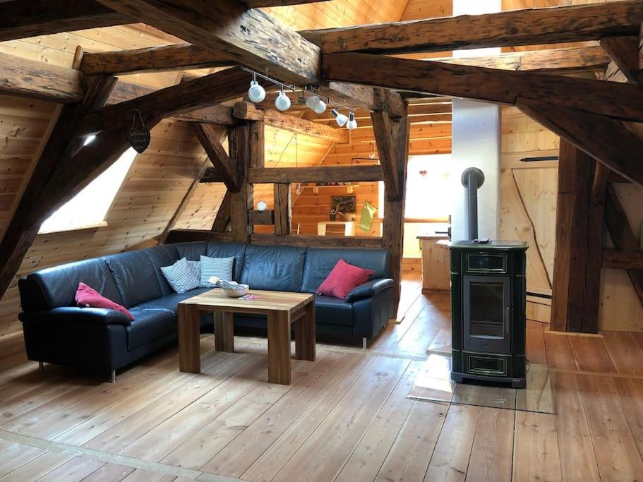- un salon avec un canapé bleu et un poêle à bois dans l'établissement gemütliches Apartment mit Galerie im Ferienhof, à Litzendorf