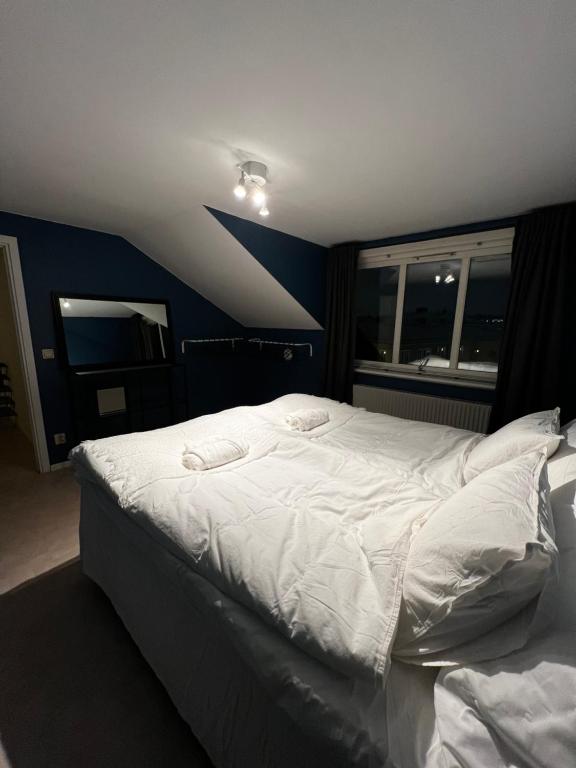 - un grand lit blanc dans une chambre avec fenêtre dans l'établissement Mysig lägenhet!, à Göteborg