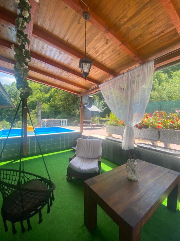 eine Terrasse mit einer Hängematte, einem Tisch und einer Schaukel in der Unterkunft Lavanda house in Konjic