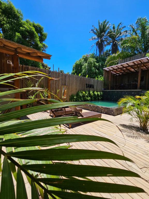 un jardín con banco, valla y piscina en Tawa Caraíva, en Caraíva