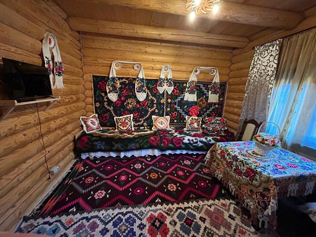 una habitación con una mesa y una cama en una cabaña en Casa Ilies, en Rozavlea