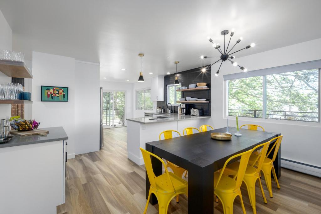 eine Küche und ein Esszimmer mit einem schwarzen Tisch und gelben Stühlen in der Unterkunft Renovated 3BD 2BA Escape w Hot Tub and City Views in Salt Lake City