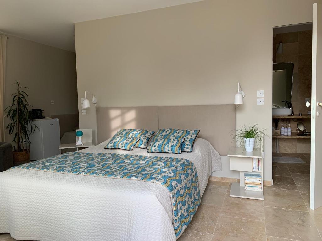 a bedroom with a large bed with blue sheets at EN VILLE à LA CAMPAGNE 2 in Louhans