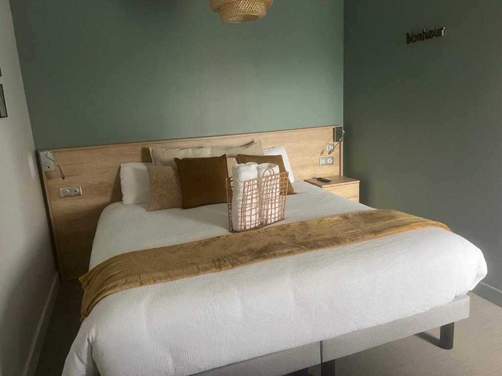 a bedroom with a bed with white sheets and pillows at Chambre privatisée L’Ermitage vue sur la mayenne in Château-Gontier