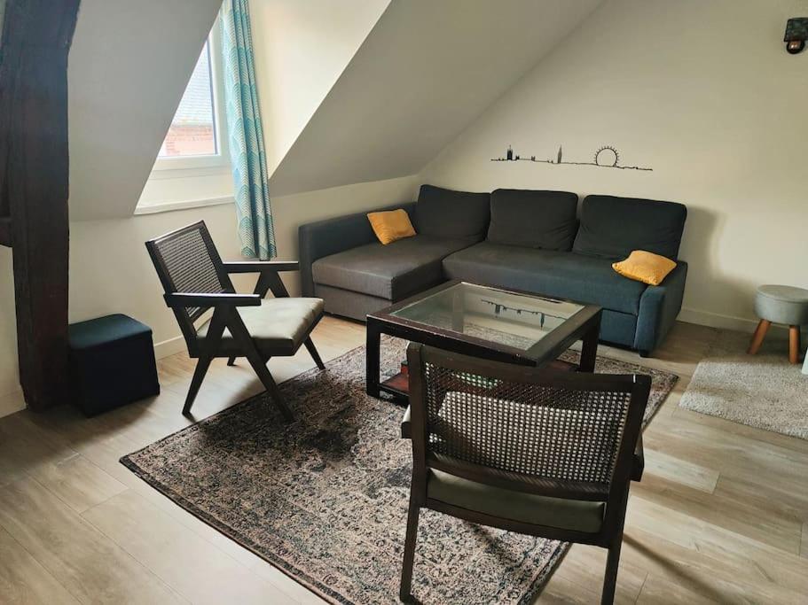 - un salon avec un canapé, une table et des chaises dans l'établissement Cosy, central et convivial, à Trouville-sur-Mer