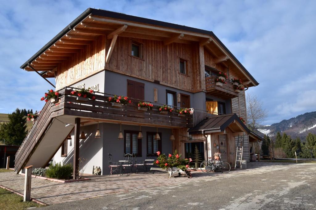 a large wooden house with flowers on the balcony at B&B Ronco Carbon in Gallio