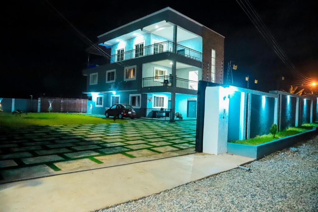 Una casa con luces azules en el costado. en Ayan Villas en Accra