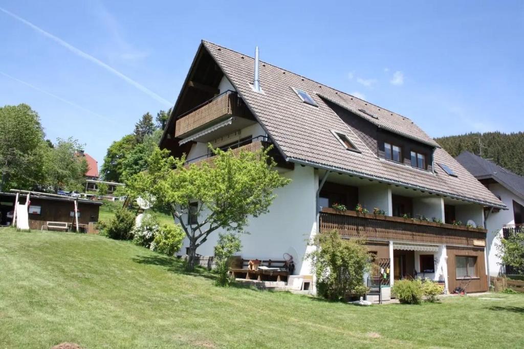 uma casa grande com um relvado verde em frente em Haus am Südhang em Lenzkirch