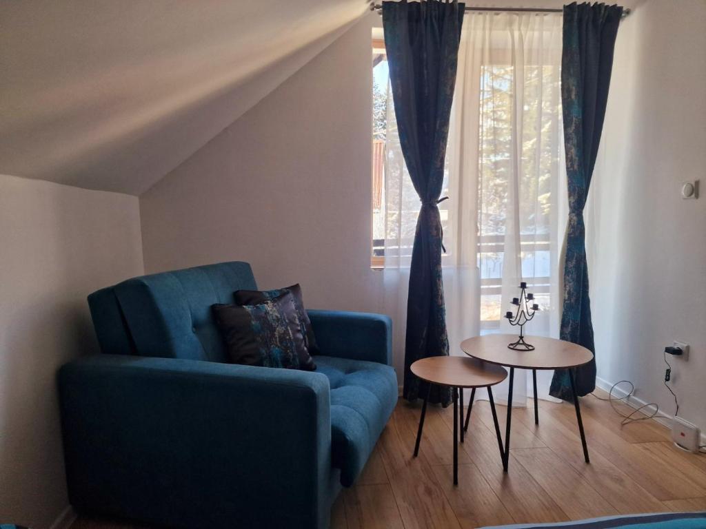 sala de estar con sofá azul y mesa en Holiday home Ravna Planina en Pale