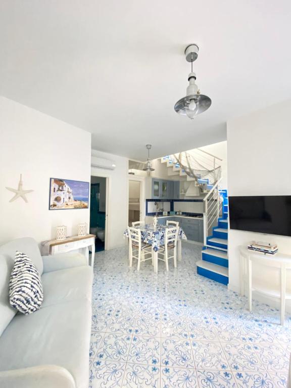 a living room with a white couch and a staircase at Arime Apartment in Ischia