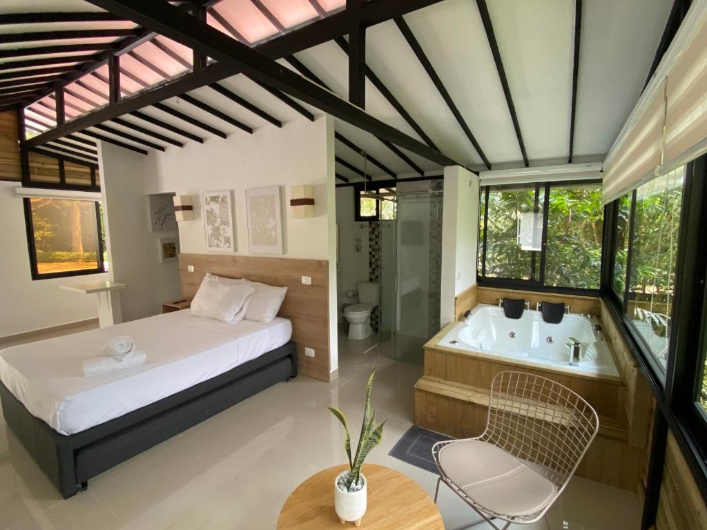 um quarto com uma cama, uma banheira e uma mesa em CRISTALES DEL RIO RESORT em São Rafael