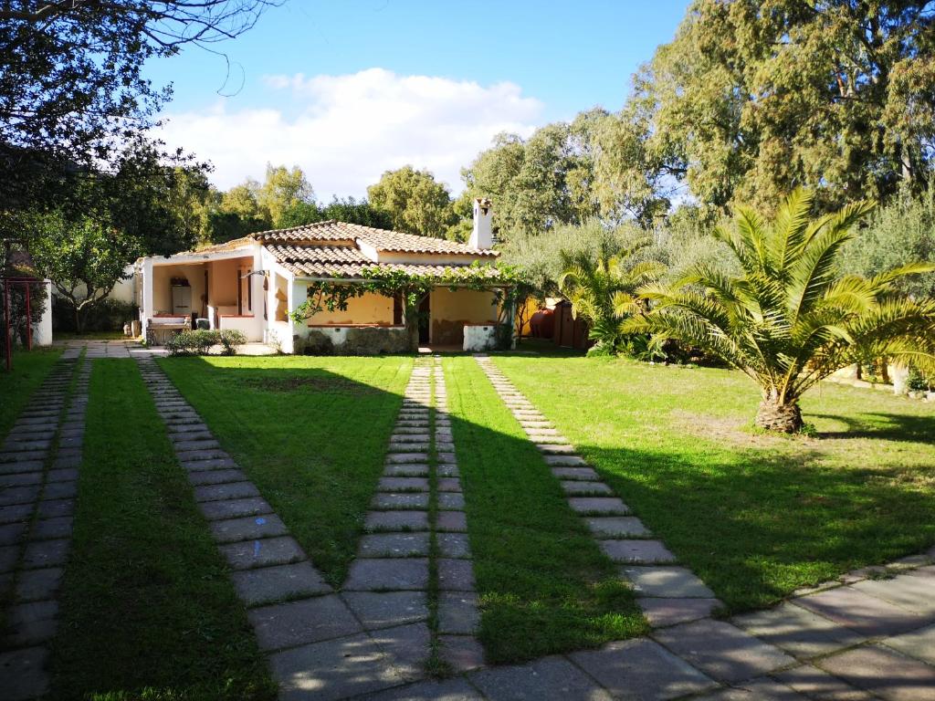 einen Garten mit einem Haus im Hintergrund in der Unterkunft Sagittario House in Torre delle Stelle