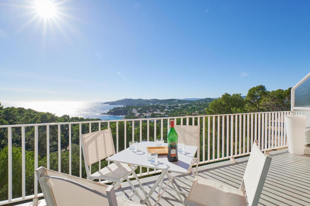 una mesa con una botella de vino en el balcón en 1Mirand3, en Llafranc