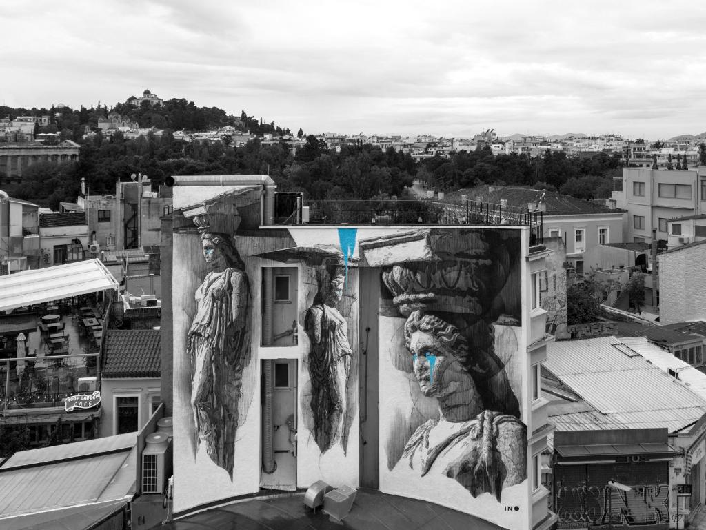 un bâtiment avec des peintures sur son côté dans l'établissement The Athens Version Luxury Suites, à Athènes