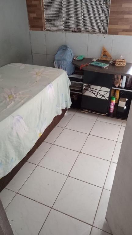 a room with a bed and a table and a tiled floor at Kitnet recife carnaval 2024 in Recife