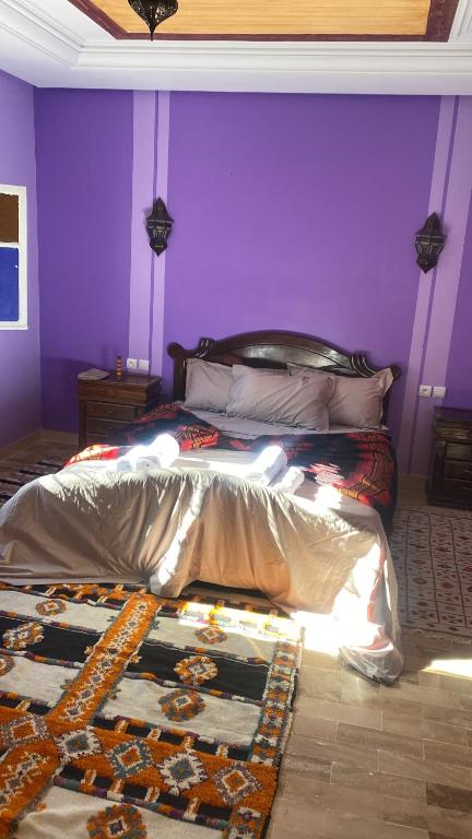 una camera con un letto con una parete viola di Gite TALBOURINE a Taroudant