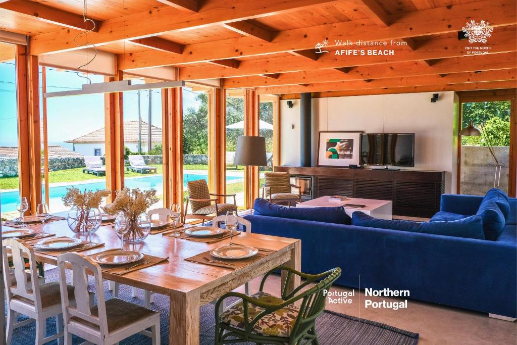 アフィフェにあるPortugal Active Atlantic Lodge -SEA VIEW -Premiumのリビングルーム(木製テーブル、青いソファ付)